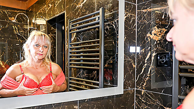 Tarty blonde granny plays solo with a sex toy in the bathroom