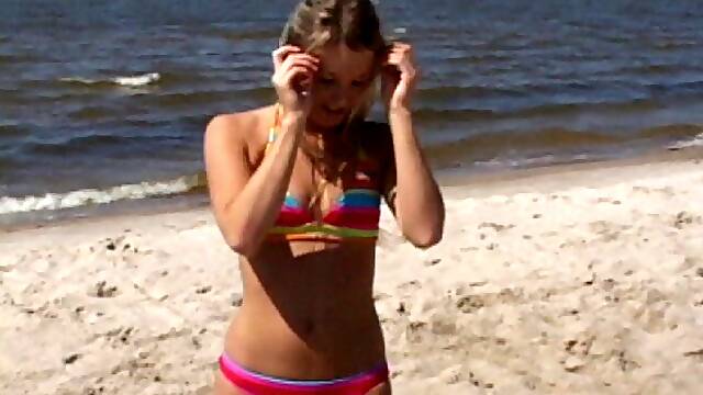 Hula hooping hottie on the beach in a colorful bikini