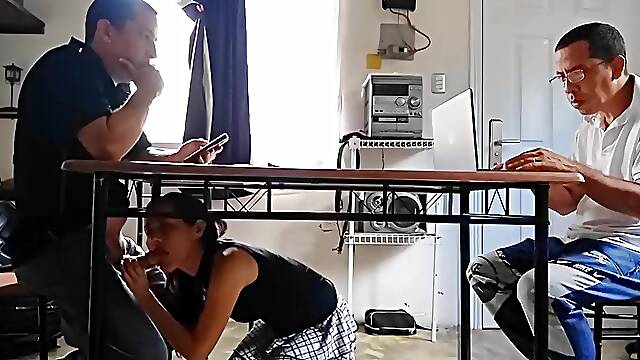 Unfaithful wife sucks the collectors schlong and swallows the cum behind the cuckolds back underneath the table.