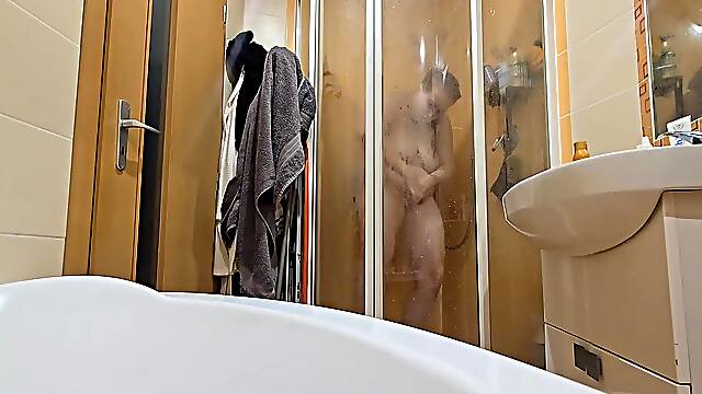 A breasty big beautiful woman showering in the shower cabin, shaving her armpits, snatch, and legs