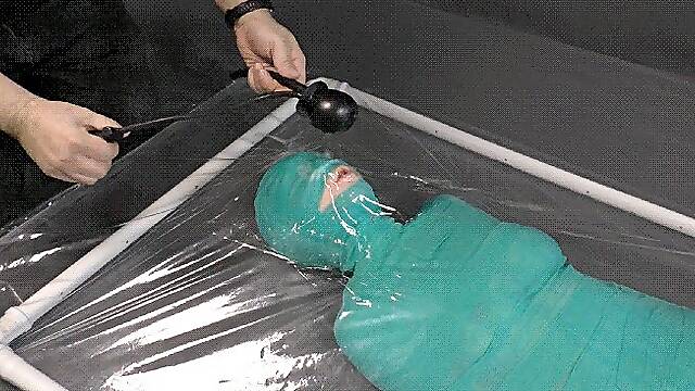 Mummification bandage vibrator and inflatable gag in a vacuum bed